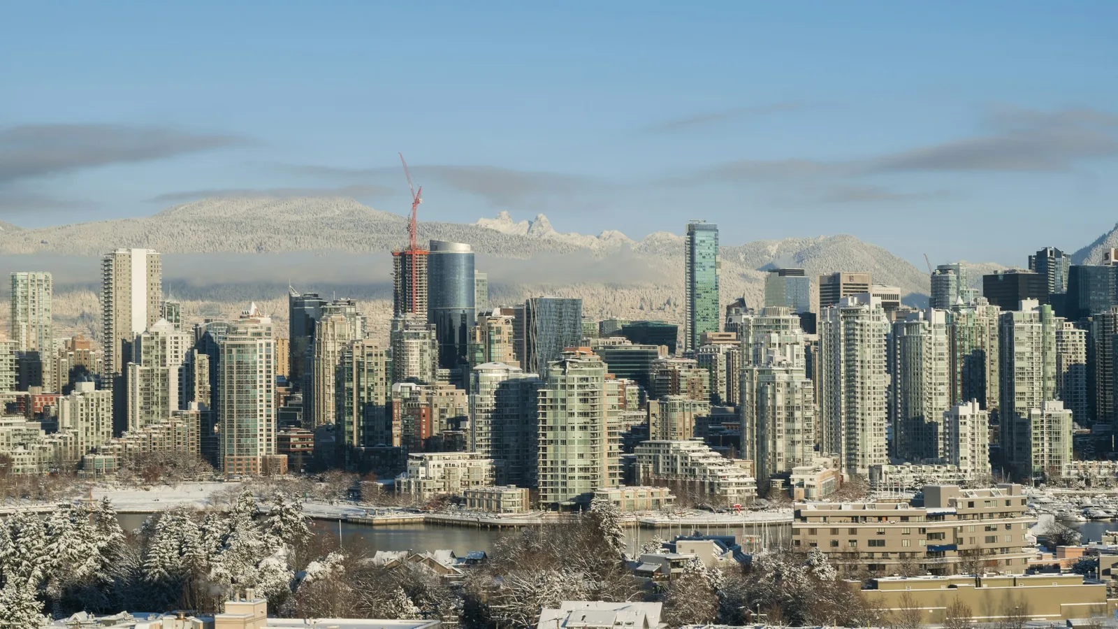 Downtown Vancouver towers under a dusting of snow with the North Shore mountains behind
