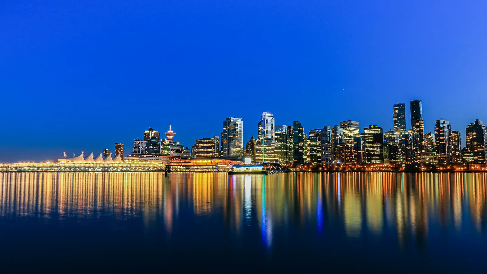 Canada Place and the Vancouver skyline reflected in Burrard Inlet at night