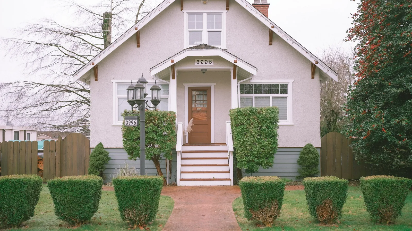 A white house with a red door and some bushes, Vancouver