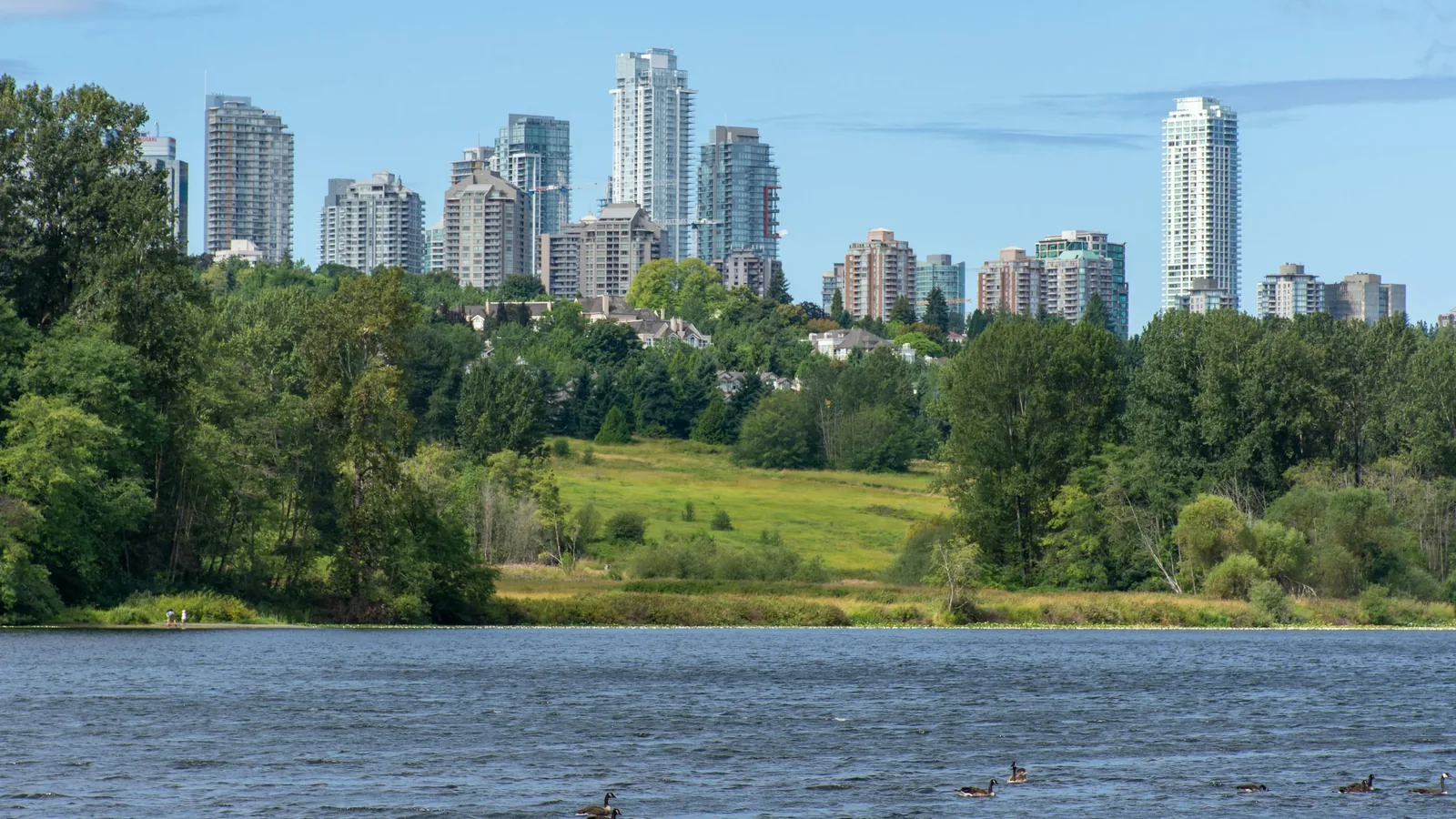 Panorama of Burnaby, British Columbia, Canada skyline from Deer Lake looking towards Metrotown and apartment complexes on a sunny summer day