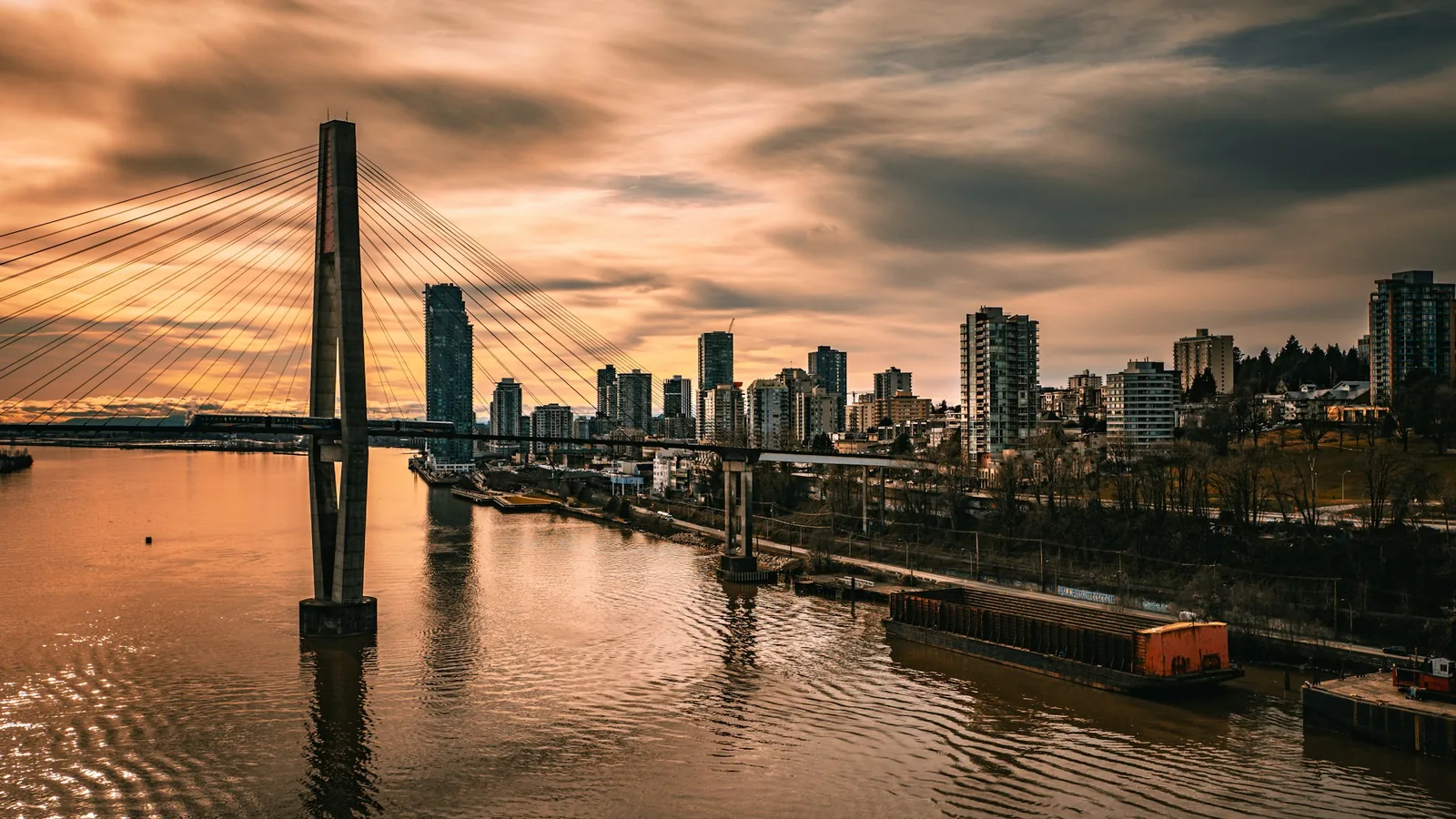 City skyline with bridge over water at sunset in New Westminster