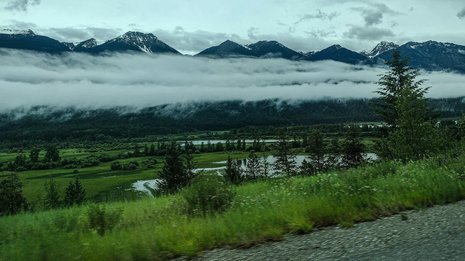 Fog lifting off a Fraser Valley floodplain below the mountains