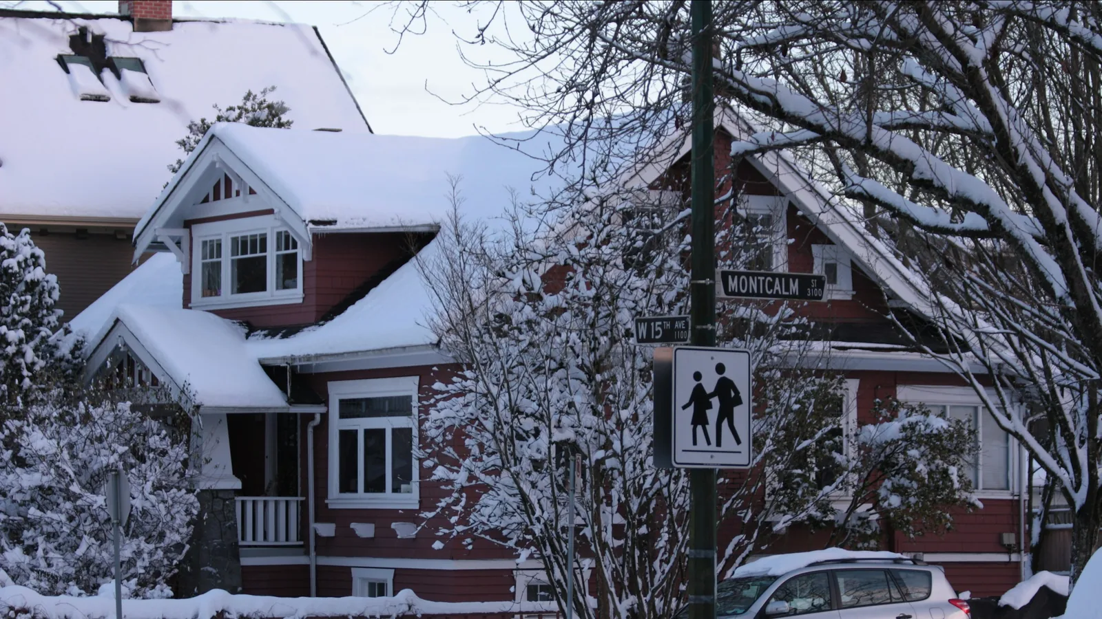 A couple of cars parked in front of a house covered in snow, Vancouver
