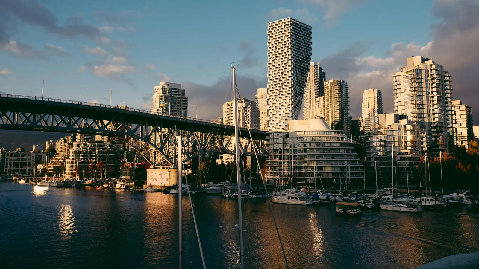 A bridge over a body of water with a city in the background, Vancouver