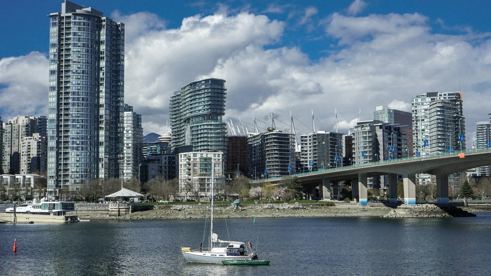 A boat is in the water in front of a city, Vancouver