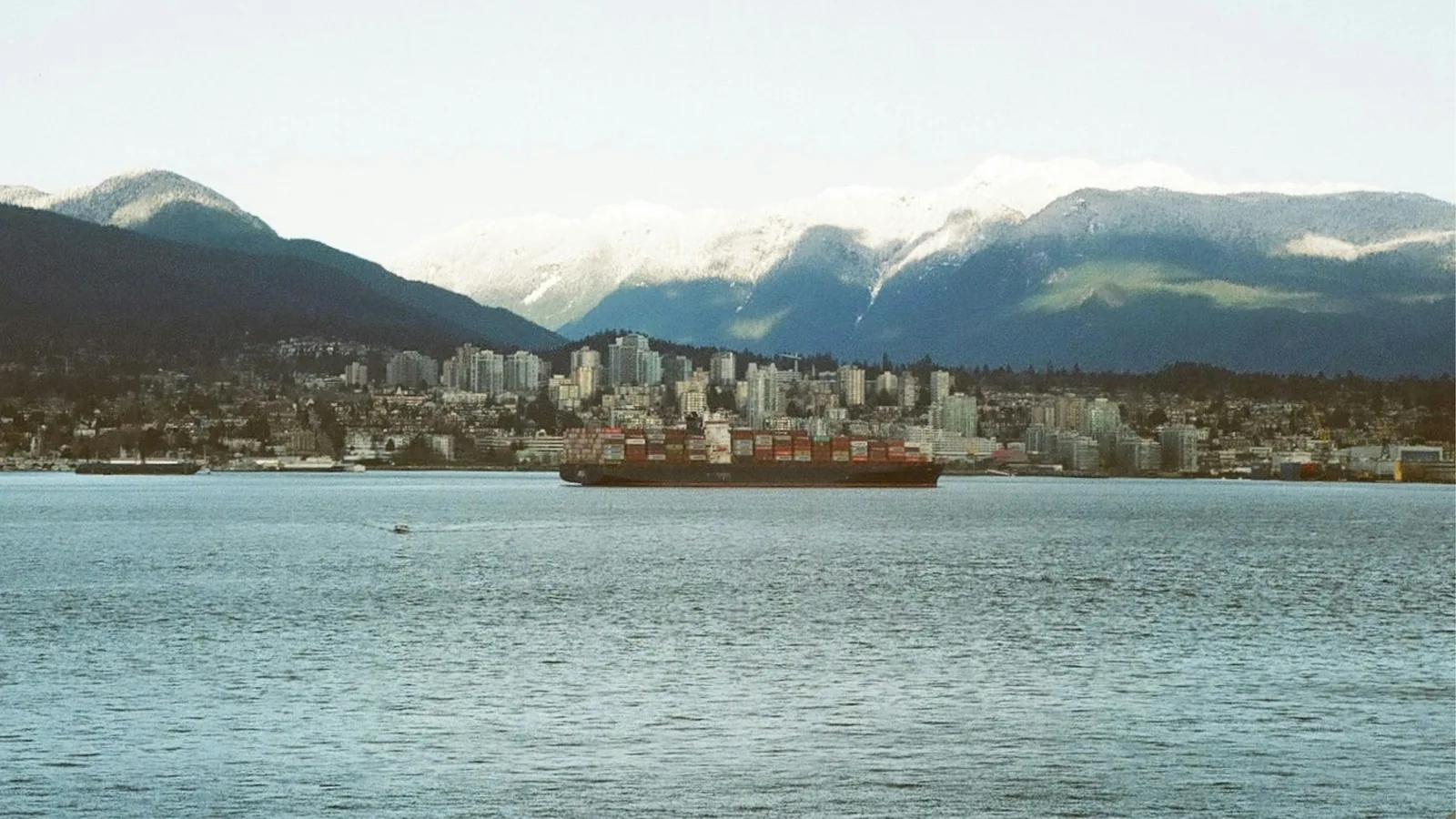Container ship passing North Vancouver with the mountains behind