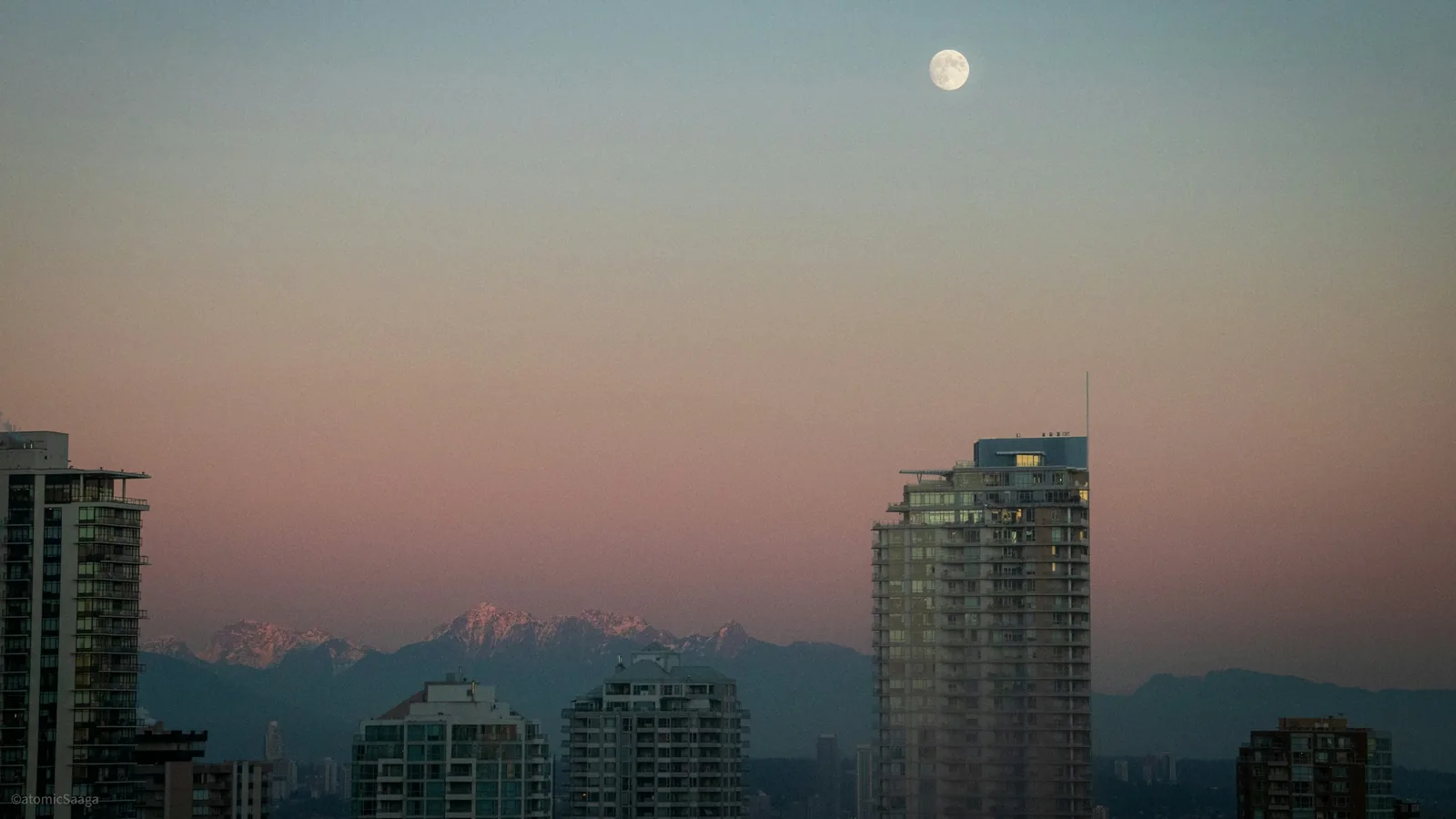 A full moon rises over a city skyline, Burnaby