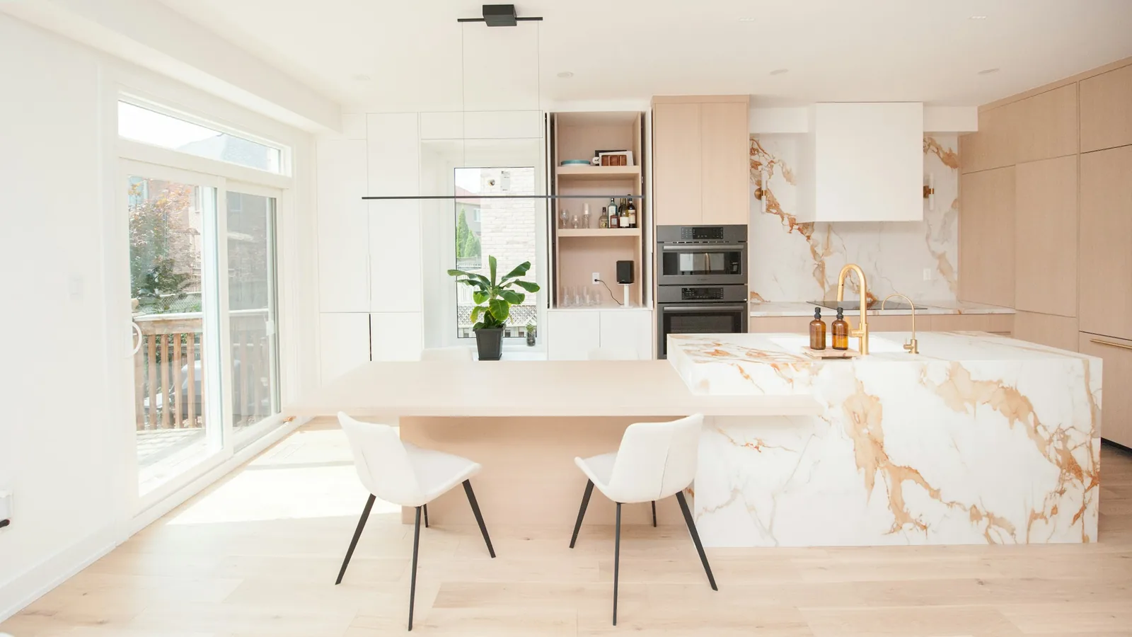 Renovated kitchen with marble island and light oak cabinets