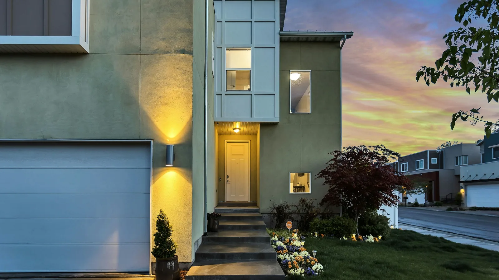 Modern townhouse entrance lit at dusk