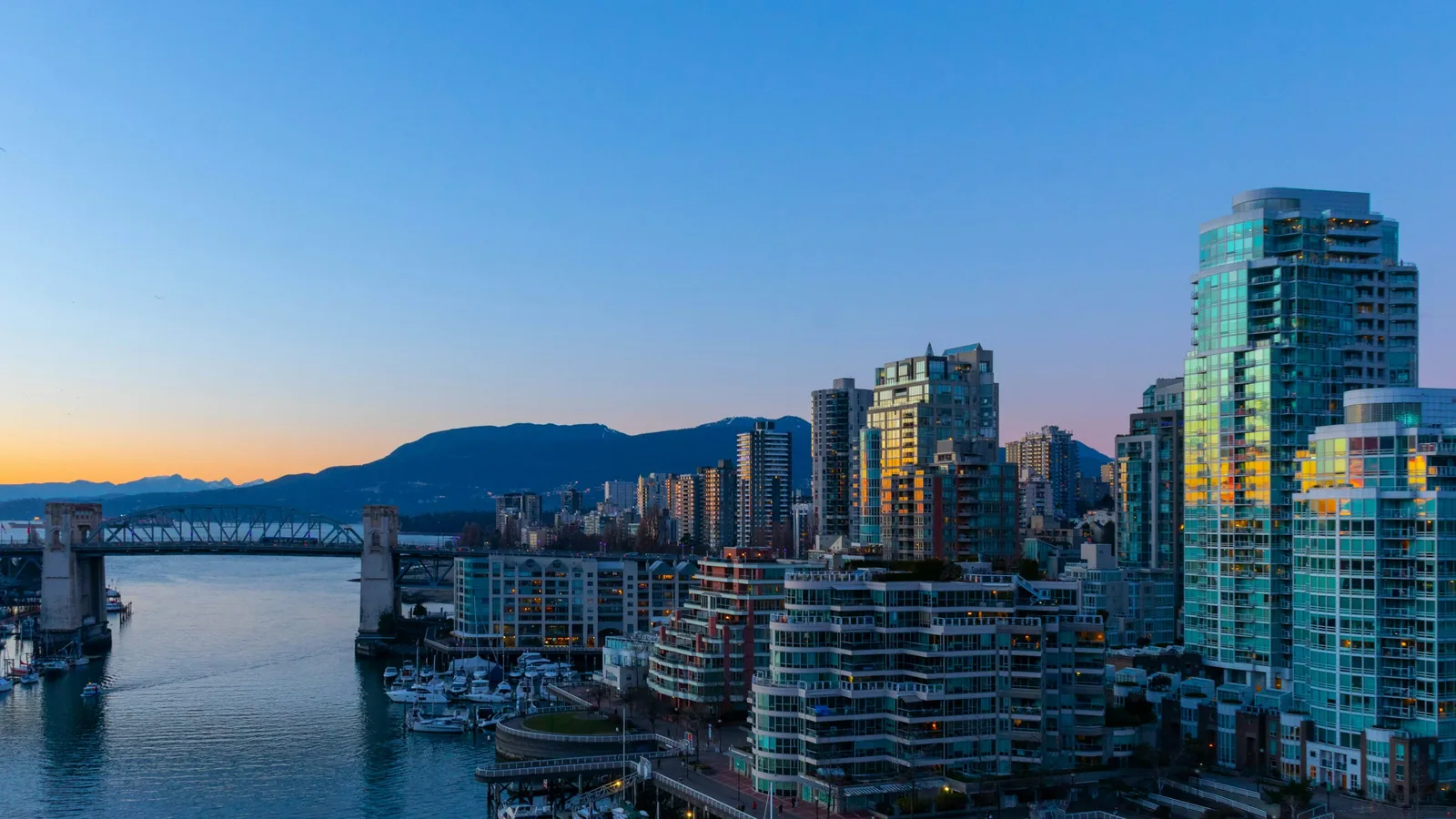Vancouver Canada West End apartment and condo towers reflecting the orange sunset horizon winter sky